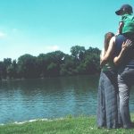 A family standing on the edge of a body of water