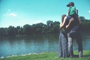 A family standing on the edge of a body of water