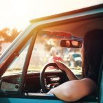 A woman driving a blue vehicle