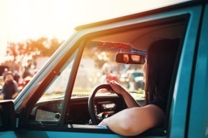 A woman driving a blue vehicle