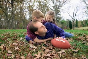 Father and children playing football