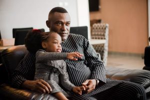 A man and a young child sitting in a chair together