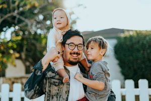 A man smiling with two small children