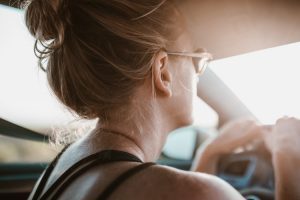 A woman driving a car while wearing sunglasses